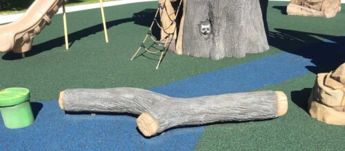 A large realistic looking branch provides a balance challenge on a playground
