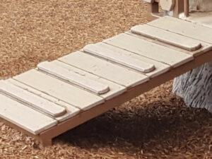 Inclined Ramp made of decking used to access a play structure for toddlers on a playground
